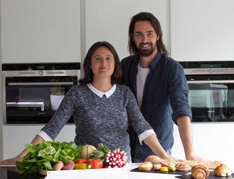 Les fondateurs d'avis de gourmets, avec des produits dans une cuisine.